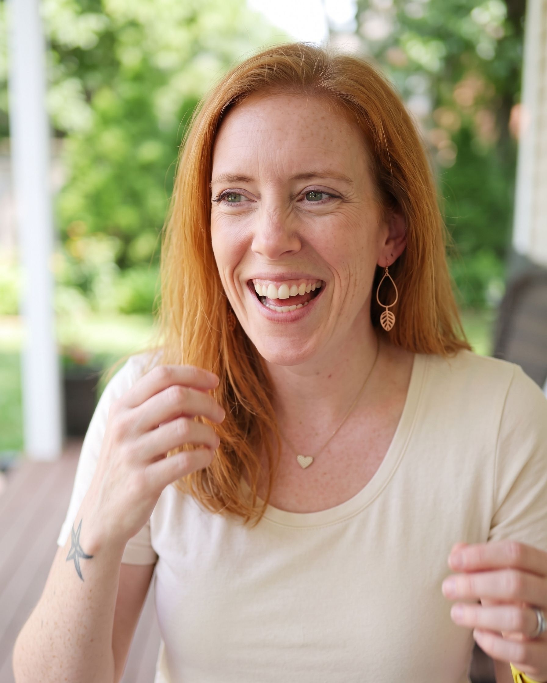Holly seated quietly in a garden setting, hands resting in her lap